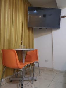 a room with a table and two chairs and a television at Hs Baltimore in Lima