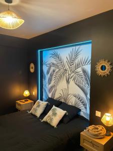 una camera da letto con un grande murale di una palma di Logement atypique-Loma room a Fougères