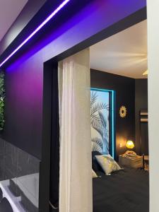 una camera da letto con letto e illuminazione viola di Logement atypique-Loma room a Fougères