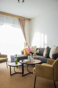 a living room with a couch and a table with flowers at City Break - Luxury Golf Estate & Country Club in Johannesburg