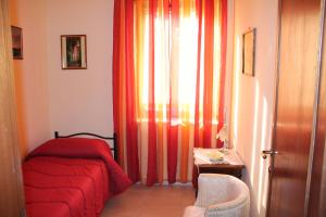 a bedroom with a red bed and a curtain at B&B A Casa Di Nonna in Fondi