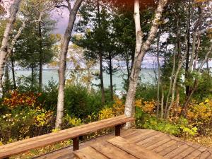 una panca di legno seduta sopra un ponte di legno di Northern Lights-Lake Michigan a Northport Altre 27 foto