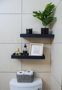 a bathroom with a toilet with two shelves on the wall at City Break - Luxury Golf Estate & Country Club in Johannesburg +15 photos