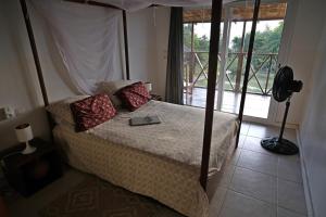 a bedroom with a bed with a book on it at Exceptional house with sea view in Cap Skirring in Boukot Ouolof +45 photos