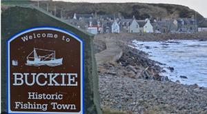 a sign for a bubbler fishing town next to a beach at Buckie Haven 3 Bed Contractors Business Travellers in Buckie +12 photos