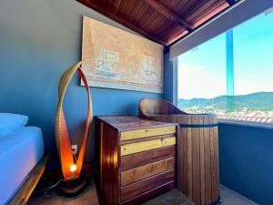 a bedroom with a bed and a desk and a window at Espaço Verano- Master 1 in Niterói