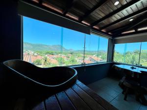 a bath tub in a room with a large window at Espaço Verano- Master 1 in Niterói +7 photos