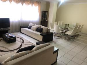 a living room with a couch and a table at Amplio depto,parqueo,zona exclusiva in Cochabamba