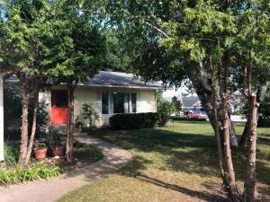 ein kleines weißes Haus mit Bäumen im Garten in der Unterkunft Suttons Bay Sunshine in Suttons Bay