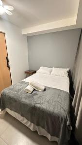 a bedroom with a large bed with a blanket at Kit 122 Brasília in Brasilia