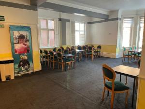 a waiting room with chairs and tables and a painting at Ullswater Hotel in Bournemouth