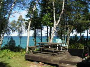 un tavolo da picnic e una panca accanto all'acqua di Northern Lights-Lake Michigan a Northport