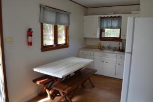 a small kitchen with a table and a refrigerator at Brookhaven 5 in Maple City +20 photos