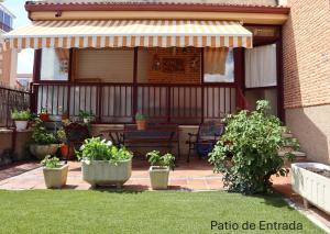 a patio of a house with a bench and an umbrella at Residencial Entreaguas in Palazuelos de Eresma