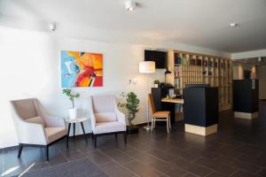 eine Lobby mit Stühlen, einem Tisch und einem Gemälde in der Unterkunft Boutique Hotel Erla in Stubenberg