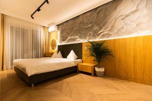 a bedroom with a bed and a potted plant at Copal Residence in Baia Mare