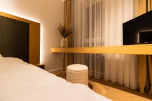 a hotel room with a bed and a flat screen tv at Copal Residence in Baia Mare