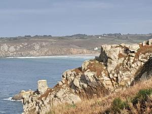 a rocky cliff next to the ocean with at Grande villa, Entre Audierne et Pointe du Raz in Primelin