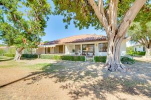 a house with a tree in front of it at Rancho Mirage Condo Near El Paseo and The River! in Rancho Mirage