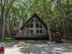 a small house in the woods with a large porch at Orchard Oaks Cottage in Glen Arbor
