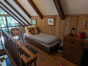 a bedroom with a bed in a room with wooden walls at Orchard Oaks Cottage in Glen Arbor