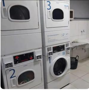 three washing machines are stacked next to each other in a kitchen at Kit 122 Brasília in Brasilia +6 photos