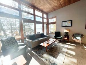 a living room with a couch and chairs and windows at Northern Comfort 2--Long Lake-Traverse City in Traverse City