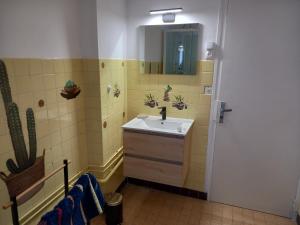 a bathroom with a sink and a mirror at Maison proche plages OMAHA BEACH in Englesqueville-la-Percée