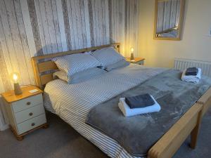 ein Schlafzimmer mit einem großen Bett mit zwei Handtüchern darauf in der Unterkunft Hope Corner in Filey