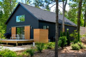 a black house with a porch in the woods at The Barn on Bay Lane in Glen Arbor