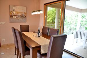 a dining room with a wooden table and chairs at Villa Amalia Apartments in Malinska