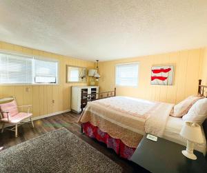 a bedroom with a bed and a chair in it at Cherry Blossom Farm in Suttons Bay