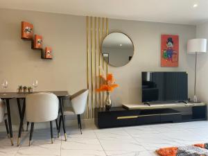 sala de estar con TV, mesa y espejo en Hermès Suite- By One Leeds Road, en Bradford