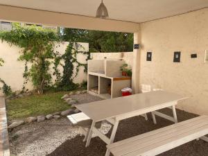 a picnic table and a bench in a backyard at Casa Olive, en complejo residencial con cochera in Godoy Cruz