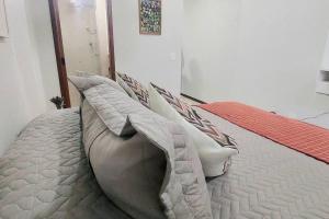 Una cama con almohadas en una habitación. en Nossa Kitnet no Sudoeste 10 minutos da Esplanada, en Brasilia