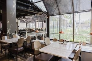 ブルーミントンにあるCrowne Plaza Suites MSP Airport - Mall of America by IHGのテーブルと椅子、大きな窓のあるレストラン