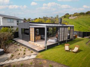 una pequeña casa en una colina con un patio trasero en Black Hut Eco Retreat en Christchurch