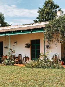 a house with a green door and a yard at Estancia Buena Vista in Esquina