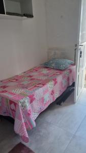 een klein bed in een kamer met een roze sprei bij Quarto verde Asa Sul in Brasilia