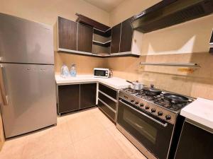 a kitchen with a stove and a stainless steel refrigerator at Suite Dream - Gulberg in Lahore