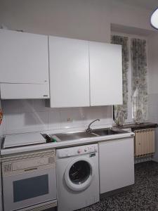 a kitchen with a washing machine and white cabinets at Meihome-Genova in Genova