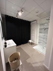 a bathroom with a shower and a black wall at L'escapade sensuelle - la love room d'Epernay in Épernay +17 photos