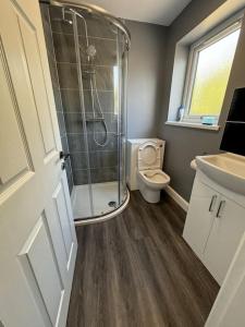a bathroom with a shower and a toilet at 5-Bedroom Cottage in New Waltham, Grimsby in Grimsby +13 photos