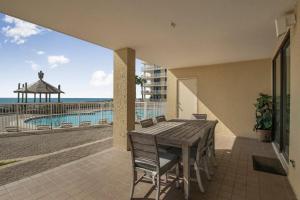 a table and chairs on a balcony with a view of the beach at Summer House 103A by Vacation Homes Collection in Orange Beach