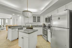 a kitchen with white cabinets and a refrigerator at Summer House 103A by Vacation Homes Collection in Orange Beach