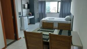 a room with a bed and a table and chairs at Executive Celita Franco in Feira de Santana