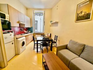 a living room with a couch and a table in a kitchen at Sublime T4 en hyper centre avec 3 chambres in Grenoble