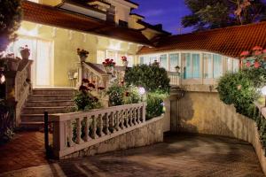 ブダペストにあるヴィラ ウェルネスの白い柵と階段と花のある家
