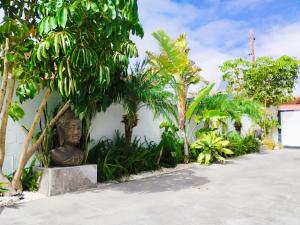 een standbeeld zittend naast een gebouw met bomen bij Angkor Wat Village in Puerto Real