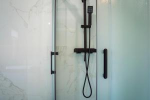 una doccia con porta in vetro e soffione di Treviso City Center BnB - Comodo per Stazione e Centro Città a Treviso Altre 19 foto